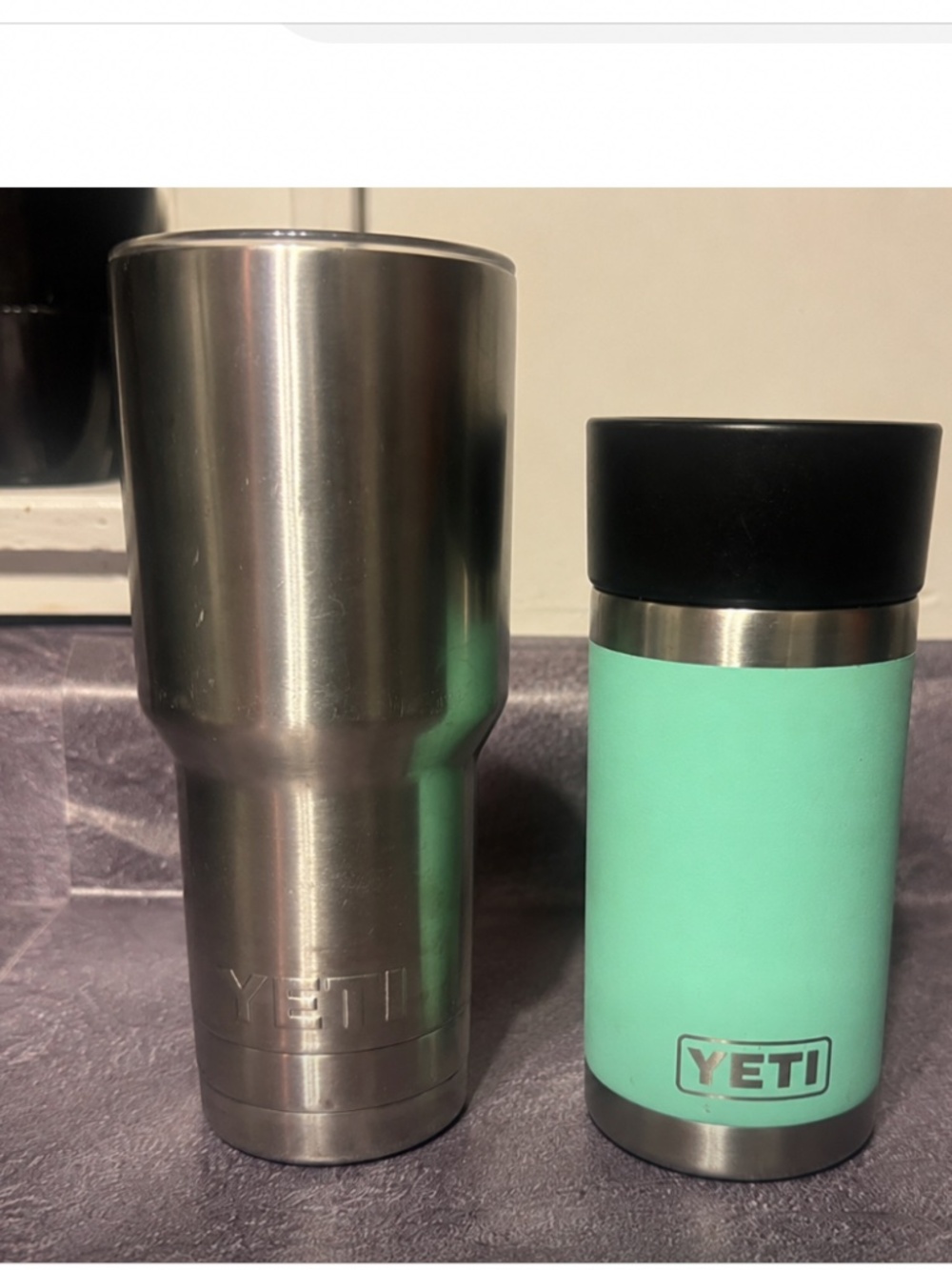 Yeti stainless steel tumbler paired with a seafoam green Rambler. Rambler featur